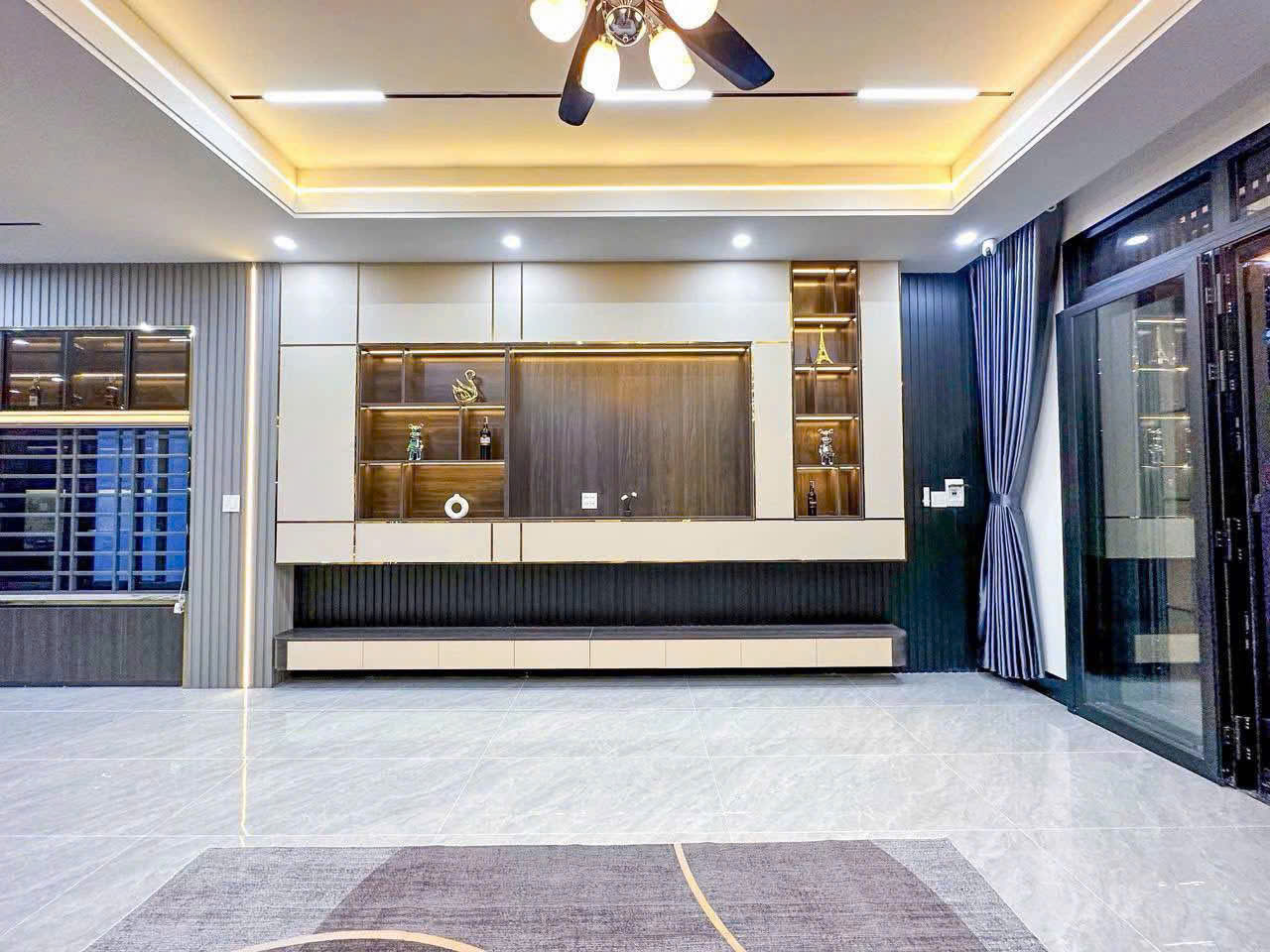 Mảng kệ phối màu sáng và màu gỗ, kết hợp các ô trưng bày chiếu sáng.