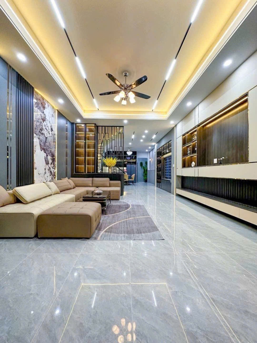 Sofa màu be kết hợp thảm và mảng trang trí vân đá trong phòng khách.