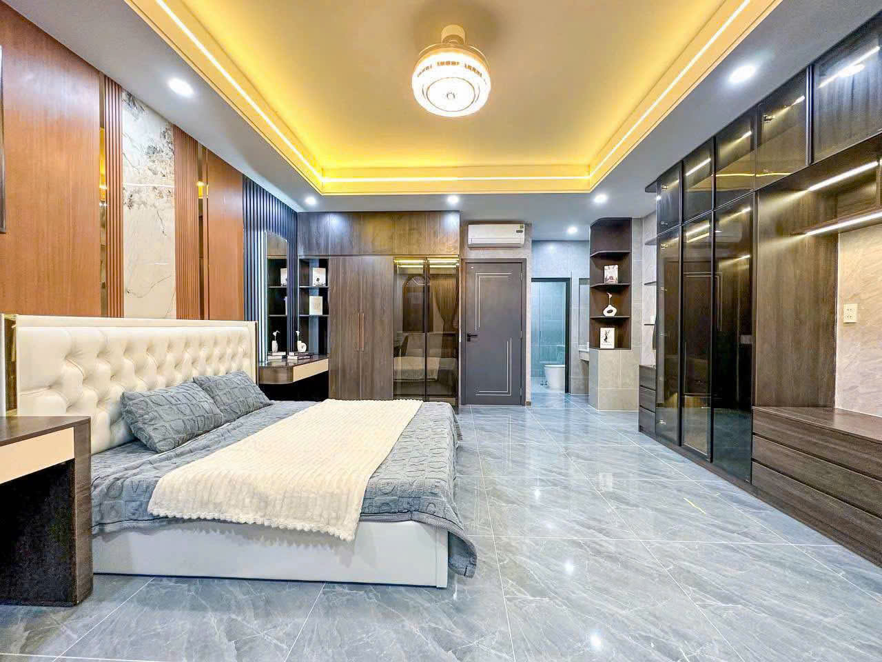 Vách đầu giường và hệ tủ tạo sự đồng bộ cho không gian phòng ngủ.