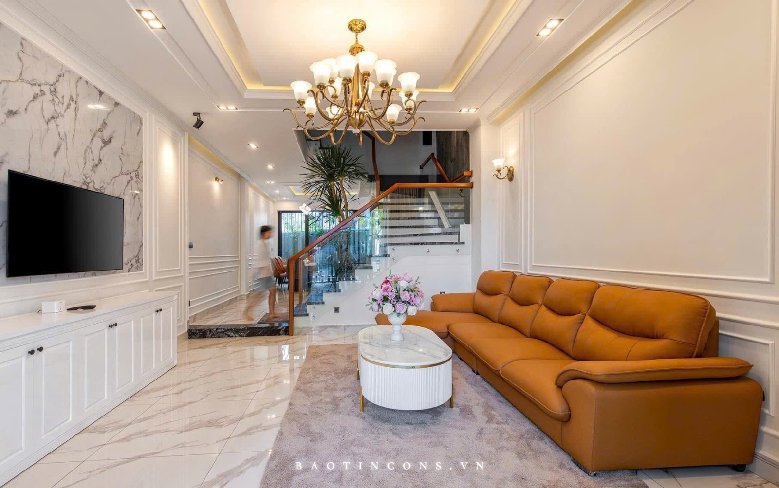  Sofa màu ấm tạo điểm nhấn trên nền nội thất trắng và các bề mặt vân đá.